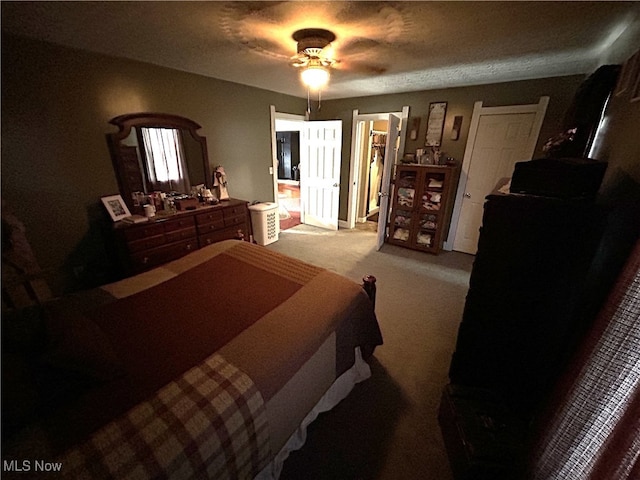 carpeted bedroom with a textured ceiling and ceiling fan