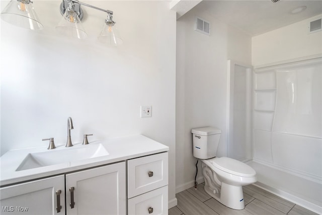 bathroom featuring a shower, vanity, wood-type flooring, and toilet