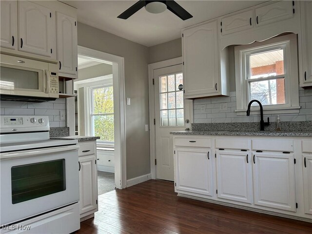 kitchen featuring white cabinets, decorative backsplash, dark hardwood / wood-style flooring, and white appliances