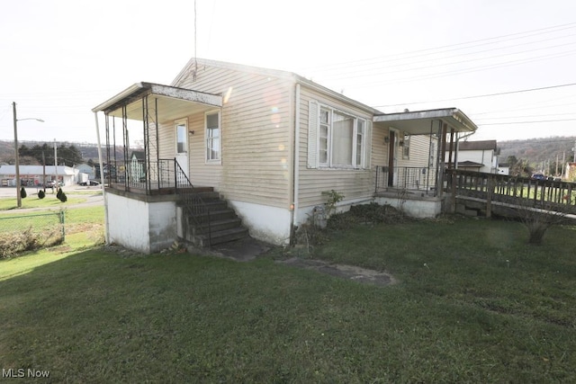 view of side of property with a porch and a yard