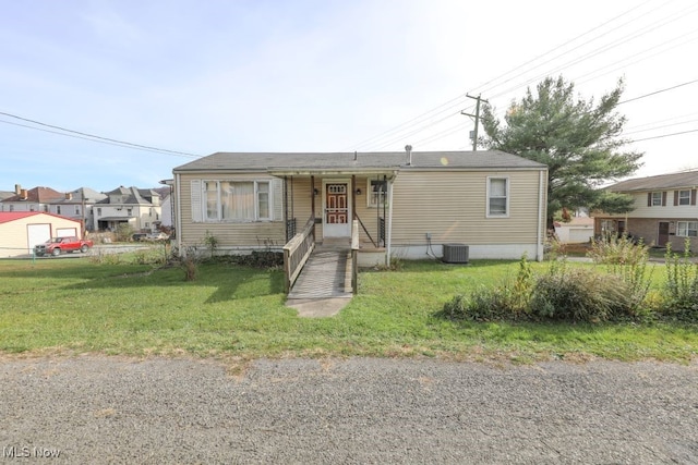 view of front facade featuring central AC unit and a front yard