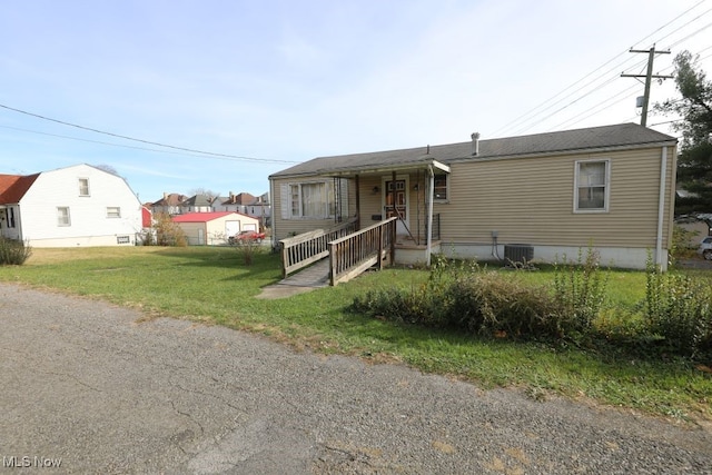 view of front facade featuring central AC unit and a front yard