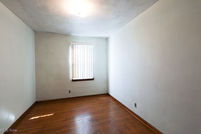 spare room featuring dark wood-type flooring