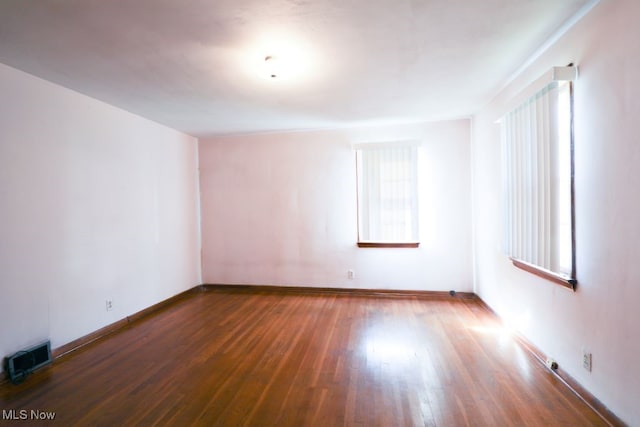 unfurnished room with dark wood-type flooring