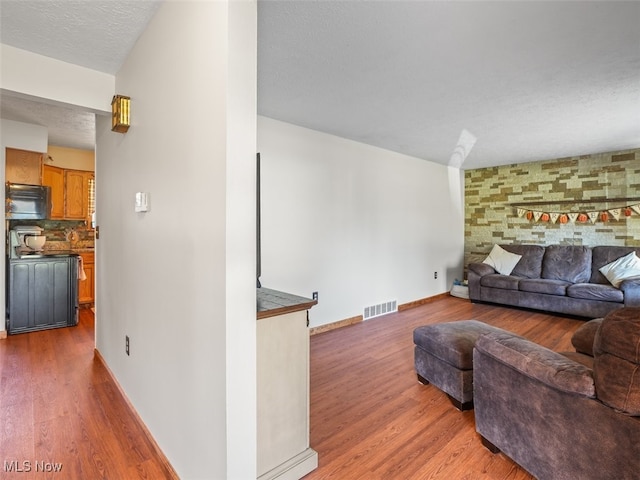 living room with wood-type flooring and a textured ceiling