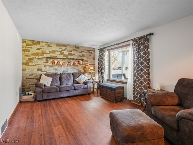 living room featuring wood-type flooring and a textured ceiling