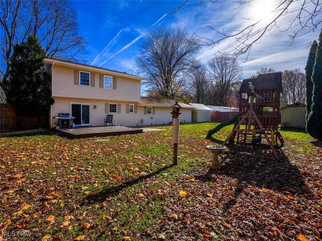 back of property featuring a lawn and a playground