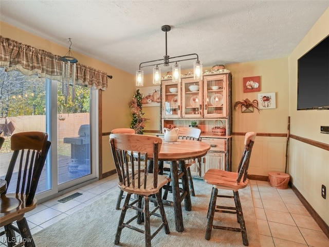 tiled dining room with a textured ceiling