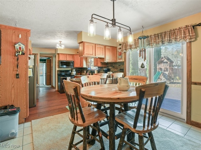 tiled dining space featuring a textured ceiling