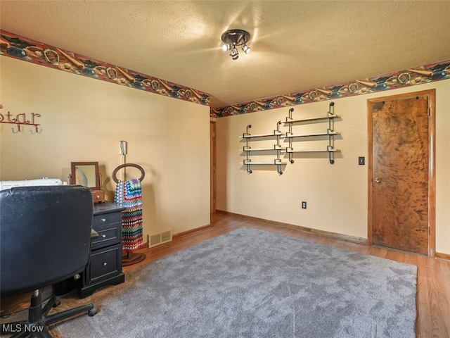 office area with a textured ceiling and hardwood / wood-style flooring