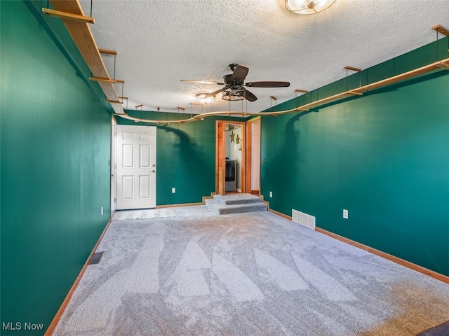 empty room with ceiling fan, carpet, and a textured ceiling