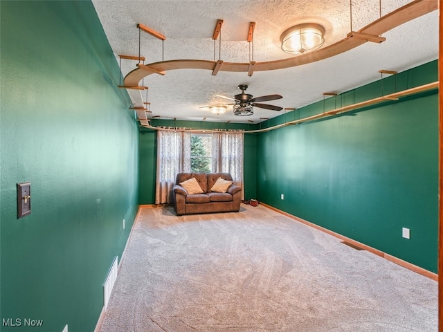 unfurnished room featuring ceiling fan, carpet floors, and a textured ceiling