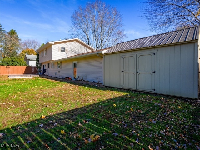 view of side of property featuring a storage unit and a lawn