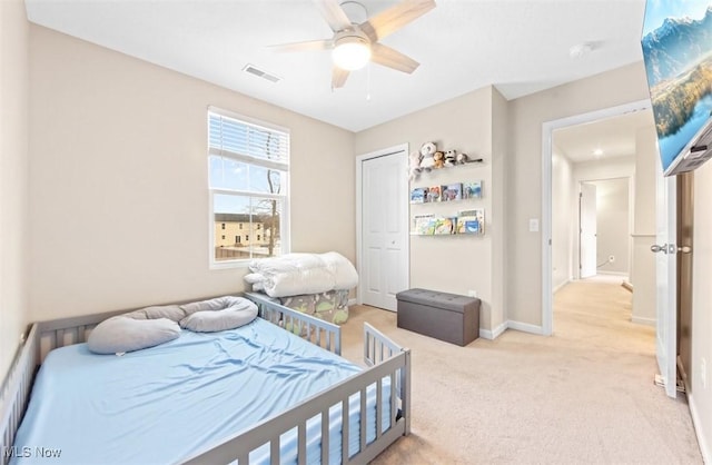 carpeted bedroom featuring ceiling fan and a closet