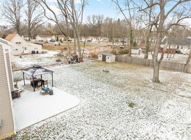 yard covered in snow featuring a gazebo and a storage shed