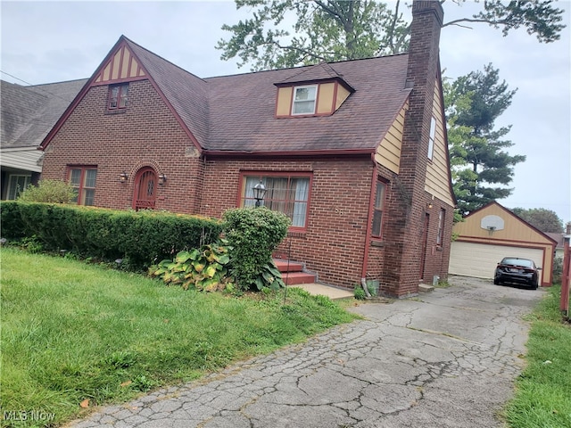 view of front of home with an outbuilding, a garage, and a front lawn