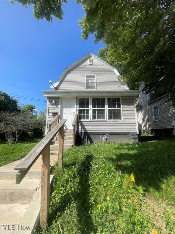 rear view of property with a yard