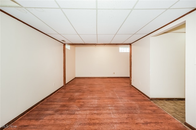 basement with hardwood / wood-style floors and a paneled ceiling