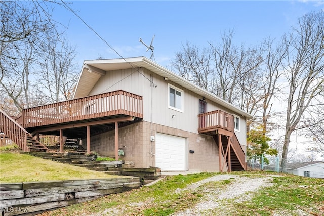 back of property with a garage and a deck