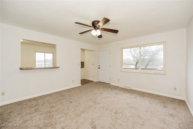 carpeted spare room with ceiling fan