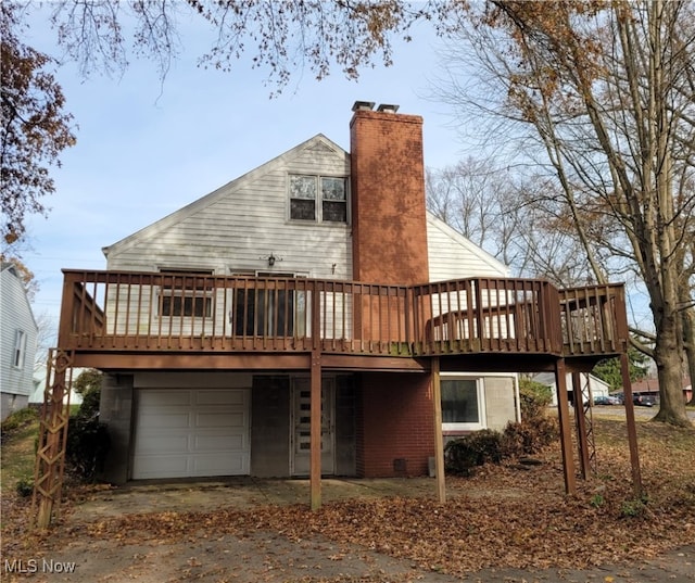 back of house featuring a deck and a garage