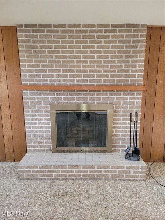 room details featuring carpet flooring and a brick fireplace