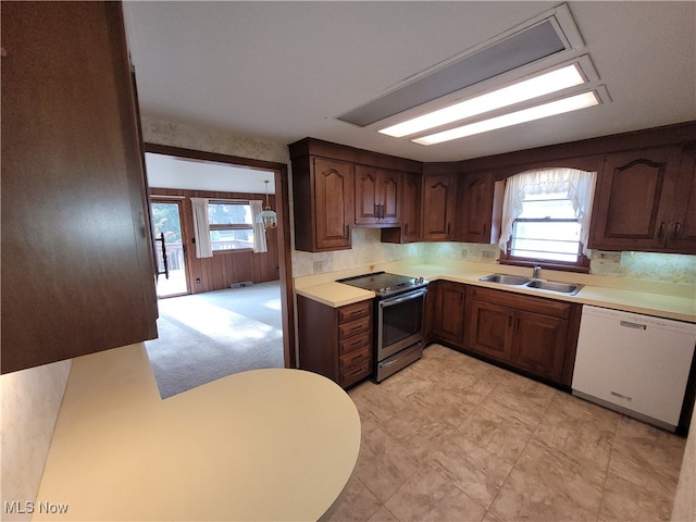 kitchen with dishwasher, stainless steel electric stove, sink, dark brown cabinets, and light colored carpet