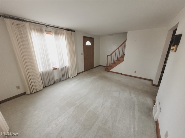 unfurnished living room featuring light colored carpet