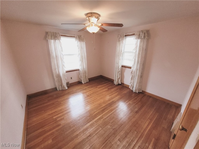 unfurnished room featuring ceiling fan, a healthy amount of sunlight, and wood-type flooring