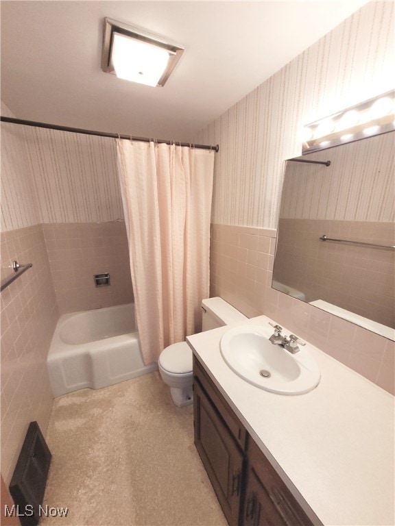 full bathroom with shower / tub combo, vanity, tile walls, and toilet