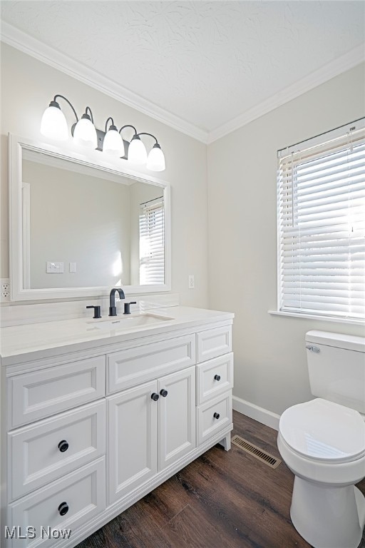 bathroom with hardwood / wood-style flooring, vanity, toilet, and ornamental molding