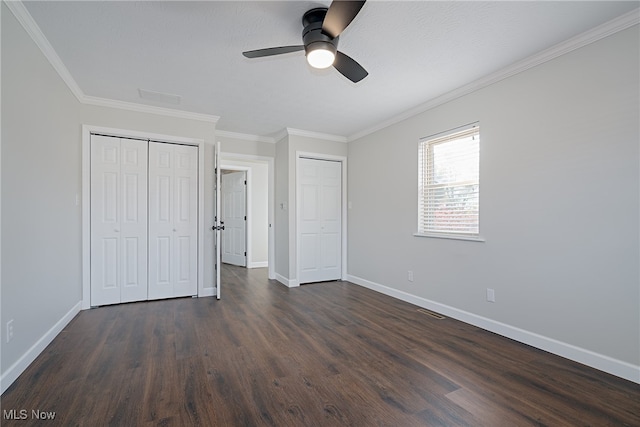 unfurnished bedroom with ceiling fan, ornamental molding, and dark wood-type flooring