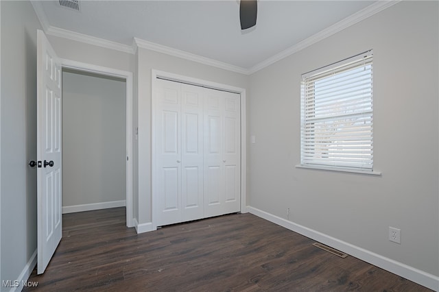 unfurnished bedroom with dark hardwood / wood-style flooring, ceiling fan, a closet, and ornamental molding