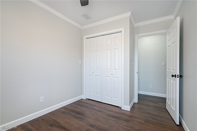 unfurnished bedroom with a closet, ceiling fan, crown molding, and dark hardwood / wood-style floors