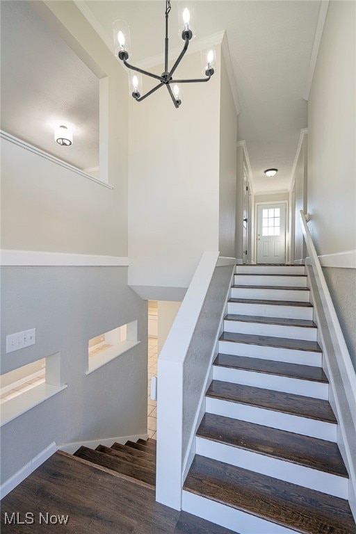 stairs featuring hardwood / wood-style flooring and ornamental molding