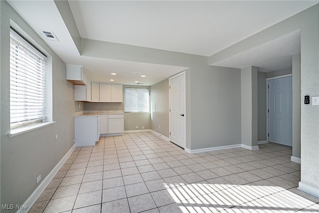 interior space with white cabinetry and light tile patterned floors