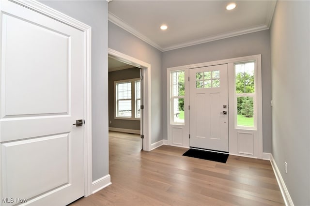 foyer entrance featuring light hardwood / wood-style flooring and ornamental molding