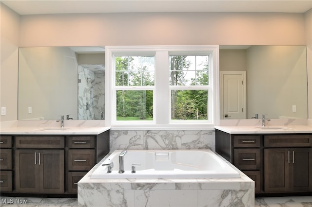 bathroom featuring vanity and a relaxing tiled tub