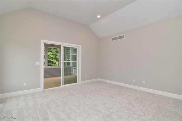 unfurnished room featuring carpet flooring and lofted ceiling