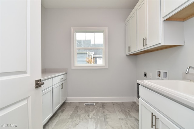 washroom featuring hookup for an electric dryer, washer hookup, cabinets, and sink