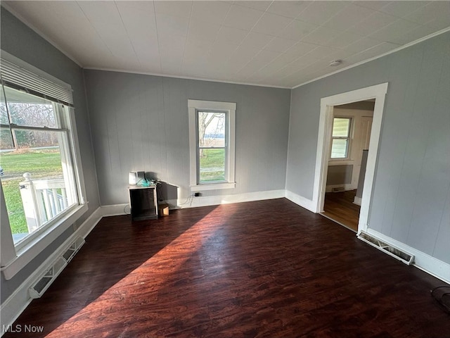 unfurnished room featuring ornamental molding and dark wood-type flooring