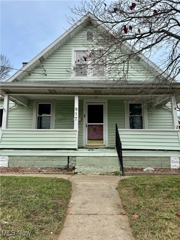 bungalow-style home with a front lawn