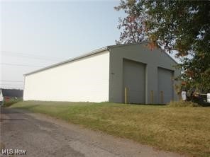 view of outbuilding with a lawn and a garage