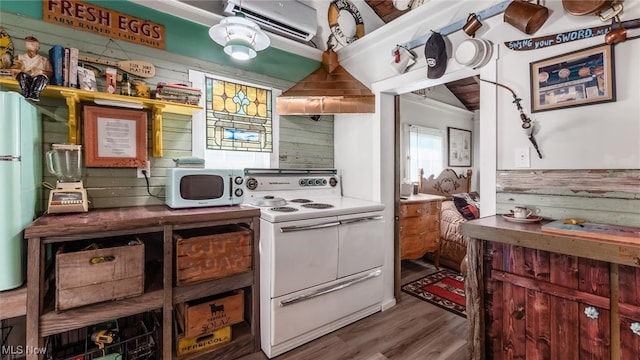 kitchen with an AC wall unit, wooden walls, wood-type flooring, and white appliances