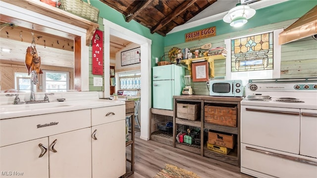 kitchen featuring white appliances, white cabinets, vaulted ceiling with beams, wood ceiling, and extractor fan