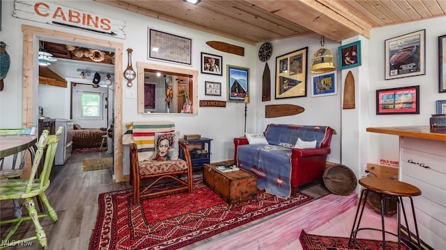 sitting room with hardwood / wood-style floors, lofted ceiling with beams, and wooden ceiling