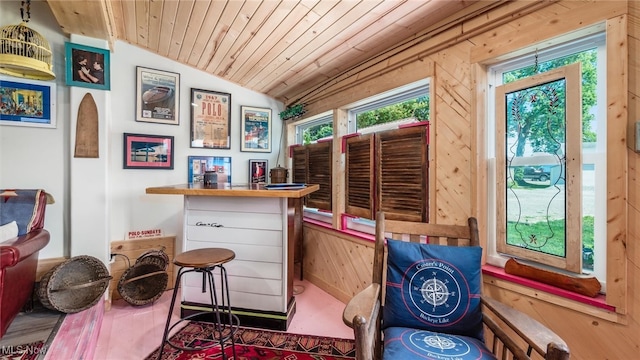 sitting room featuring bar area, wood walls, wooden ceiling, and lofted ceiling