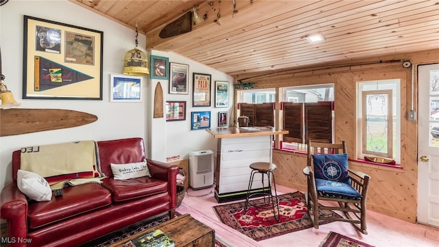 sitting room featuring lofted ceiling, wooden ceiling, wooden walls, and indoor bar