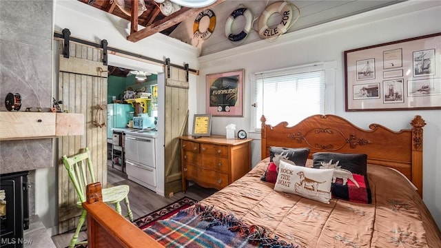 13977 Custers Point Rd NE, Thornville, OH 43076 - bedroom featuring a barn door, wood finished floors, and a fireplace