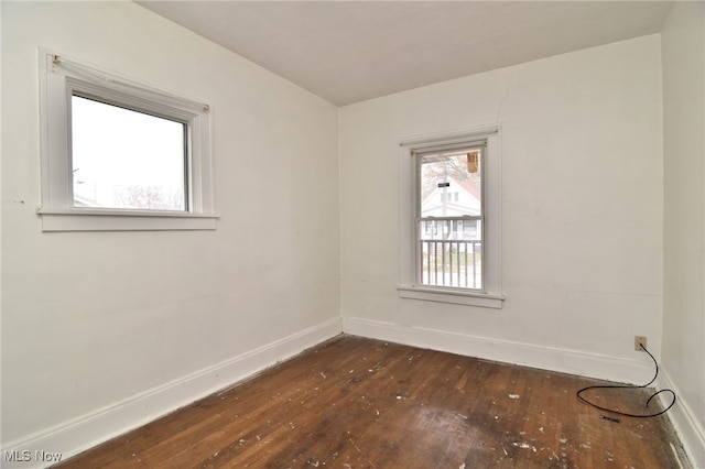 unfurnished room with dark hardwood / wood-style flooring